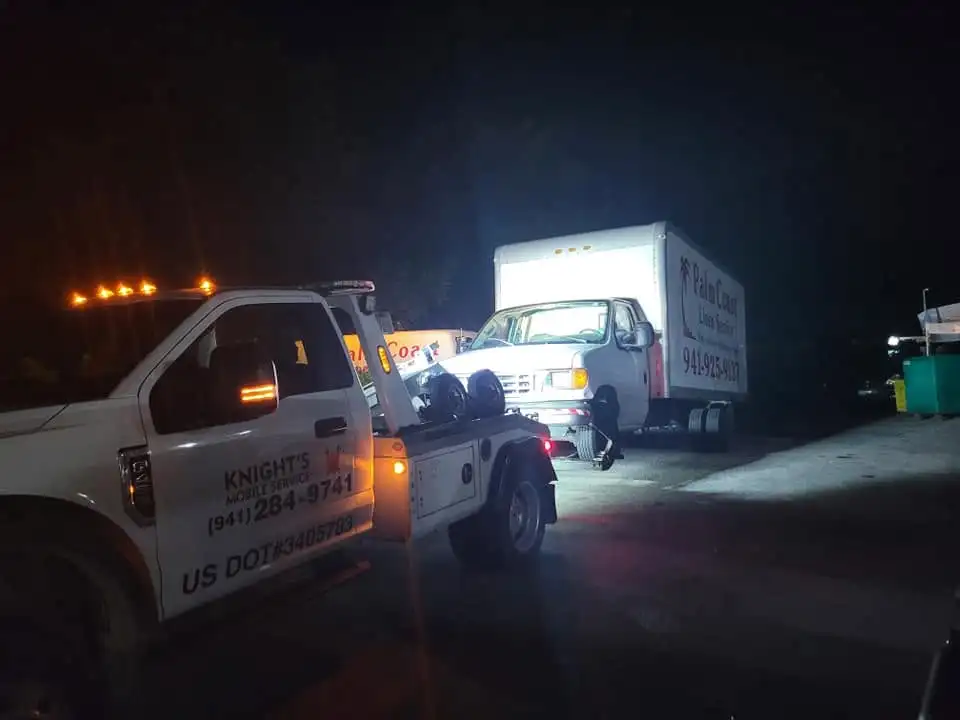 Knights Mobile Service tow truck providing service at night with amber lights on